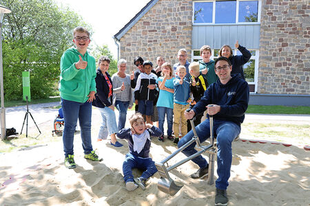 Gruppenfoto: Kinder im Sandkasten mit dem Sandbagger